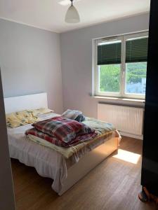 グディニャにあるApartament Gdynia Obłuże 56m2のベッドルーム1室(ベッド1台、窓2つ付)