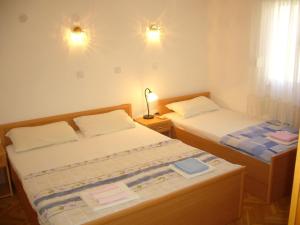 1 dormitorio con 2 camas, lámpara y ventana en MARINOVIC APARTMENTS en Budva