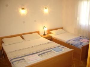 Un dormitorio con dos camas y una lámpara y una ventana. en MARINOVIC APARTMENTS, en Budva