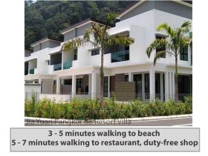 a white building with palm trees in front of it at Pangkor 88 Villa Jia Yuan 邦咯岛家苑海滩度假别墅 in Kampong Pasir Bogak