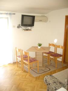 mesa de comedor y sillas con TV en la pared en MARINOVIC APARTMENTS en Budva