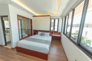 sypialnia z łóżkiem w pokoju z oknami w obiekcie Villa FLC BT 10 -04 w Ha Long