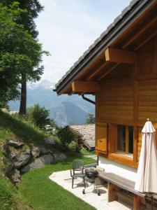 a wooden house with a bench and a grill at Chalet Arc-en-Ciel in Nendaz