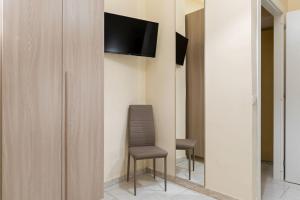 a room with a chair and a television on a wall at Casa del Pescatore in Castellammare di Stabia