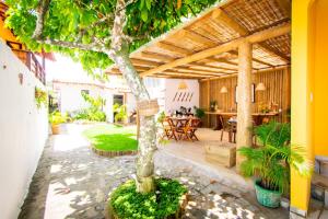 a courtyard with a tree in a house at Pousada Por do Sol in Trancoso