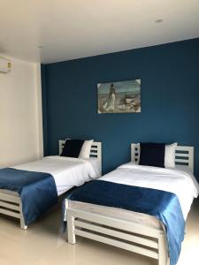 2 letti in una camera con pareti blu di SiRi Resort a Maha Sarakham