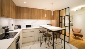 a kitchen with a counter and stools in it at Appartement COSY Hypercentre in Strasbourg