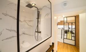 a bathroom with a shower with marble walls at Appartement COSY Hypercentre in Strasbourg