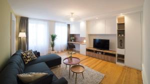 a living room with a blue couch and a table at Appartement COSY Hypercentre in Strasbourg