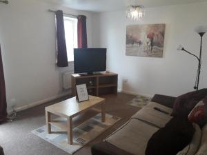 a living room with a couch and a tv at Greenock Home Stay in Wolverhampton