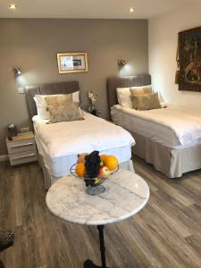 Zimmer mit 2 Betten und einem Tisch mit einer Obstschale in der Unterkunft Jonan House in Deal