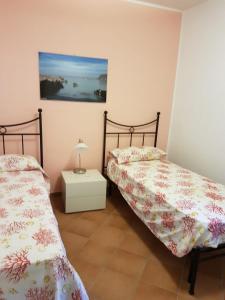 um quarto com duas camas e uma mesa de cabeceira em Trilocale Maestrale em Favignana