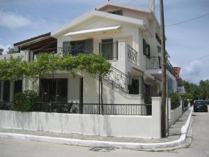 a white house with a balcony on a street at Nostalgia Apartment A in Sami 50 metres from the sea in Sami