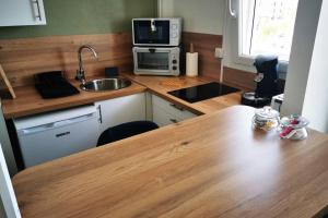 cocina con encimera de madera y mesa de madera en Le Smile en Calais