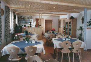 a restaurant with tables and chairs in a room at Pension zum Krug, Messe München in Hergolding