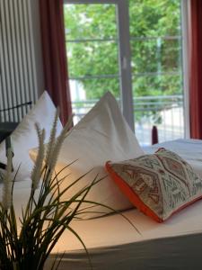 Una cama con una almohada y una planta en ella en Residenz Hotel Giessen, en Giessen