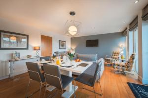 a dining room and living room with a table and chairs at Highland Apartments by Mansley in Inverness