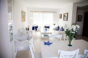 un soggiorno con mobili bianchi e un vaso di fiori di Villa Isabel a Playa de Palma