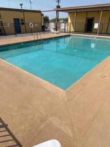 a swimming pool with blue water in a building at Gila Bend Lodge in Gila Bend