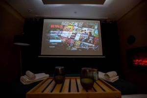 a room with a television and two glasses on a table at Nouveau - L'instant Passion - Love Room in Tourlaville