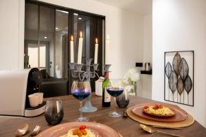 a table with two plates of food and wine glasses at Nouveau - L'instant Passion - Love Room in Tourlaville