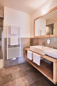 een badkamer met een wastafel en een spiegel bij Hotel Kristall in Maranza