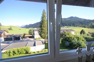 een raam met uitzicht op de bergen bij Scheiblesmoos 4 Sterne in Nesselwang