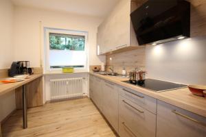 a large kitchen with a sink and a window at Scheiblesmoos 4 Sterne in Nesselwang