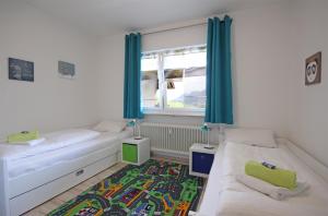 een slaapkamer met 2 bedden en een raam met blauwe gordijnen bij Scheiblesmoos 4 Sterne in Nesselwang