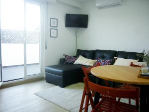 a living room with a black couch and a table at Castle, Terrace and Relax in Tomar