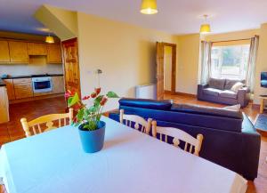 uma sala de estar com uma mesa e um sofá azul em Seacliff Holiday Homes em Dunmore East