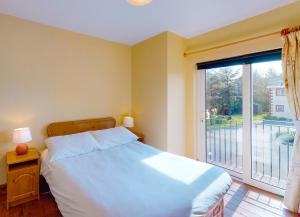 1 dormitorio con cama y ventana grande en Seacliff Holiday Homes en Dunmore East