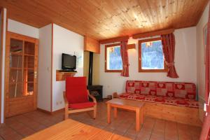 ein Wohnzimmer mit einem Sofa und einem roten Stuhl in der Unterkunft Le Meï Hameau des Chazals Nevache Hautes Alpes in Névache