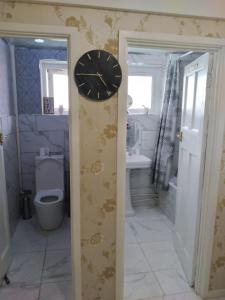a bathroom with a clock on the wall at Sea-front Apartment home-from-home in Blackpool