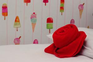 een rode handdoek bovenop een bed met ijsjes bij London Backpackers Youth Hostel 18 - 35 Years Old Only in Londen