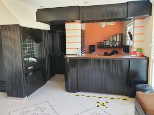 a kitchen with black cabinets and an orange wall at Hotel Atlantico a 150 mts de Playa Martí in Veracruz