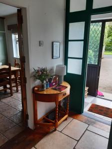 a room with a table and a green door at Peggys Escape in Ballycastle