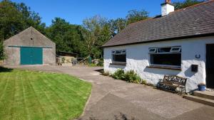 a white house with a green door and a yard at Peggys Escape in Ballycastle