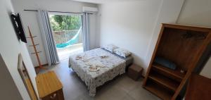 - une petite chambre avec un lit et une grande fenêtre dans l'établissement Morada da Figueira, à Bombinhas