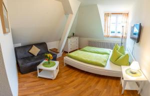 a small bedroom with a bed and a chair at Pension Glückauf in Kurort Oberwiesenthal