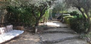 un giardino con un divano seduto sotto un albero di Mas Luis Alvarez a La Capelle-et-Masmolène