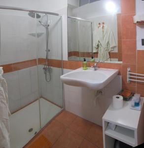 a bathroom with a shower, sink, and mirror at B&B Casa Alfareria 59 in Seville
