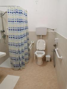 a bathroom with a toilet and a shower curtain at Cuore di Conchiglia in Custonaci