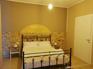 a bedroom with a bed and a stone wall at Cuore di Conchiglia in Custonaci