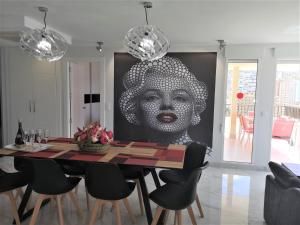 a dining room with a large painting of a woman at CASA MARCOS in Benidorm