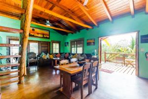 a living room with green walls and a wooden table at La Casa Pura Vida in San Pedro