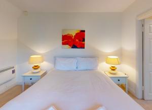 sypialnia z dużym białym łóżkiem z 2 lampami w obiekcie Lakeside Holiday Homes w mieście Killaloe