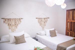 Habitación con 2 camas, paredes blancas y lámparas de araña. en Ahava Hotel, en Playa del Carmen 33 fotos más