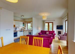 een woonkamer met een paarse bank en een tafel bij Lakeside Holiday Homes in Killaloe