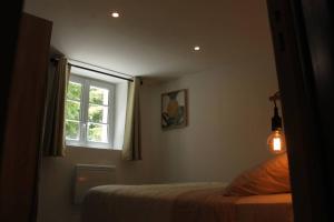 een slaapkamer met een bed en een raam bij Appartement avec vue sur la Sorgue in Fontaine-de-Vaucluse